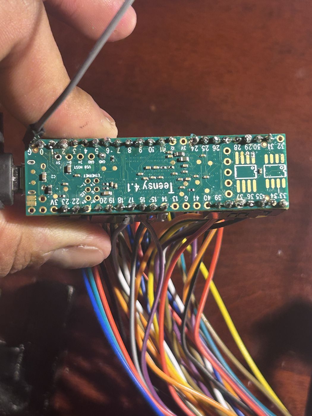 The underside of the Teensy with dozens of colored wires soldered to its pins